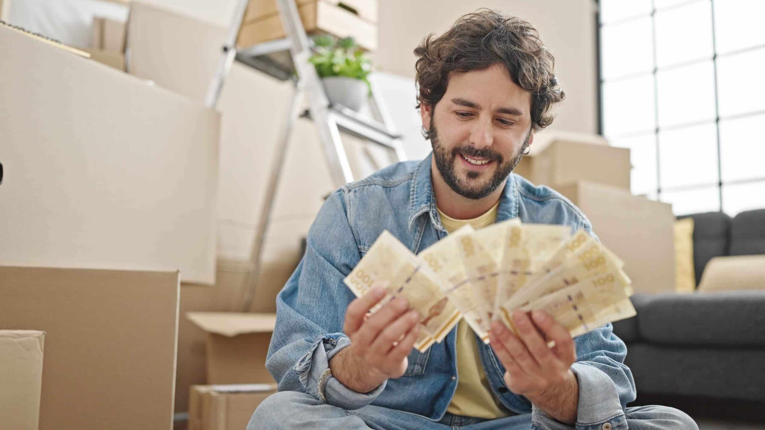 young-hispanic-man-counting-denmark-krone-banknotes-sitting-floor-new-home (1) E-Transfer Payday Loans in Edmonton