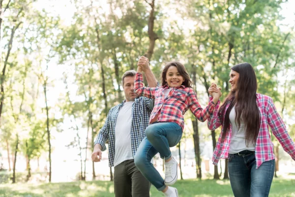 couple-lifting-their-daughter-while-walking-park